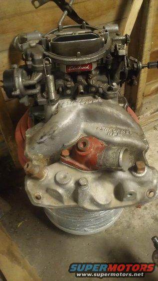 Edelbrock intake manifold with carburetor on top. Text reads "PERFORMER 1404"