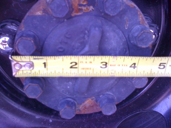 Close-up of a wheel hub with a yellow measuring tape across it
