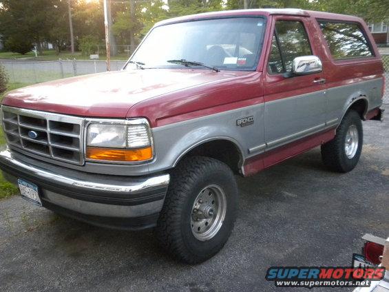 1994 Ford Bronco, two-tone red and silver, parked on asphalt