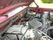 1994 Ford Bronco - The engine bay of a red 1994 Ford Bronco shows its V8 engine and associated components.