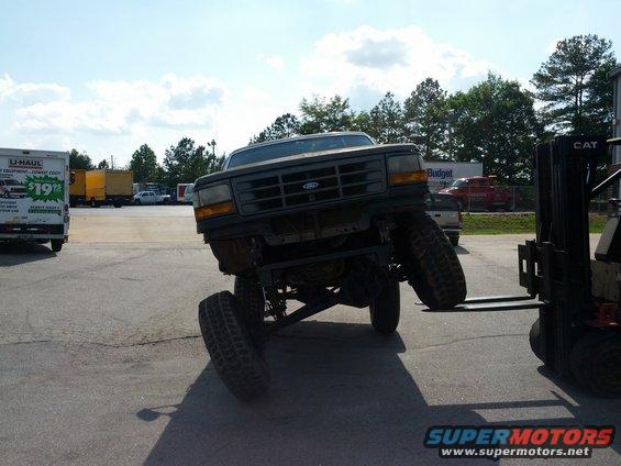 Front view of a lifted 1987 Ford Bronco being moved by a forklift