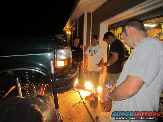 1992 Ford Bronco front end, green, being worked on by a group of men