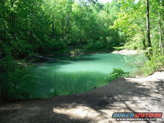 Wooded lake scene with Supermotors.net watermark