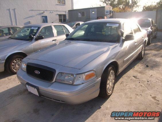 Silver 2005 Ford Crown Victoria parked outside with other cars