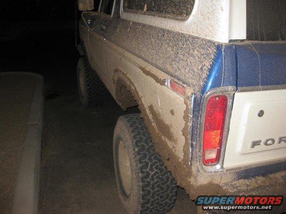 Mud-covered 1978 Ford Bronco rear quarter panel and tailgate with 'FORD' lettering visible