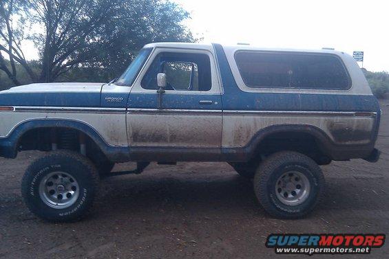 Two-tone blue and white 1978 Ford Bronco, side view, lifted, dirty