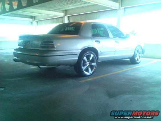 Silver 1999 Ford Crown Victoria rear 3/4 view with aftermarket wheels