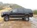 2005 Ford Excursion - Side view of a black 2005 Ford Excursion SUV with lifted suspension in snowy conditions.