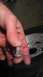 1989 Ford Bronco - Close-up of a hand holding a metal fastener, with a tire and wheel visible in the background.
