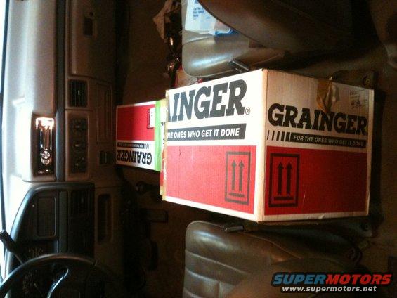 Interior of a truck cab showing two Grainger boxes stacked on a seat
