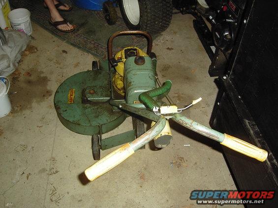 Green vintage leaf blower with yellow handles and a green hose