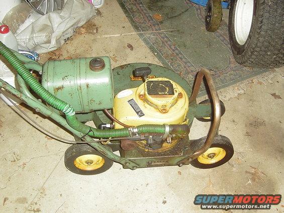 Green and yellow reel mower with a yellow gas tank and green hose