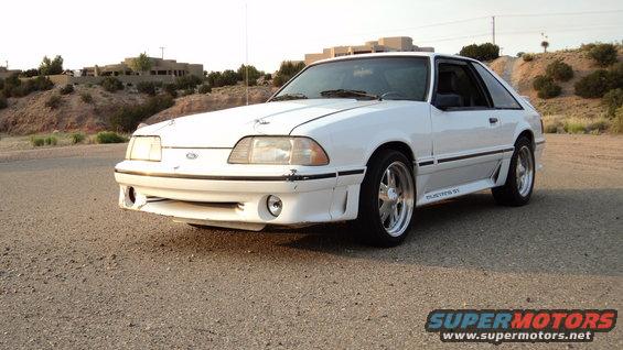 White 1989 Ford Mustang GT coupe with aftermarket wheels, front 3/4 view