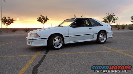 White 1989 Ford Mustang GT parked in a lot at sunset
