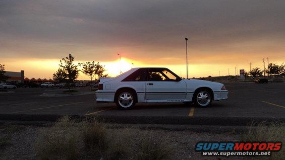 White 1989 Ford Mustang GT parked in a lot during sunset