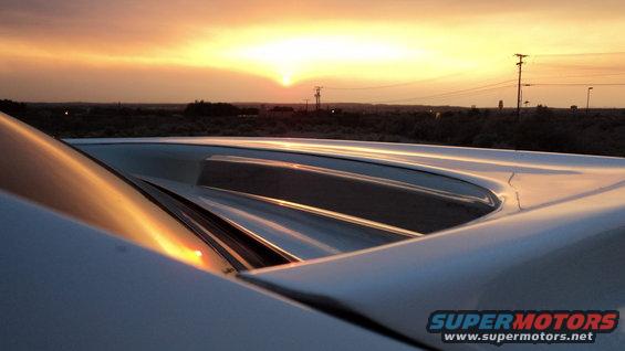 White car roof detail with louvers at sunset