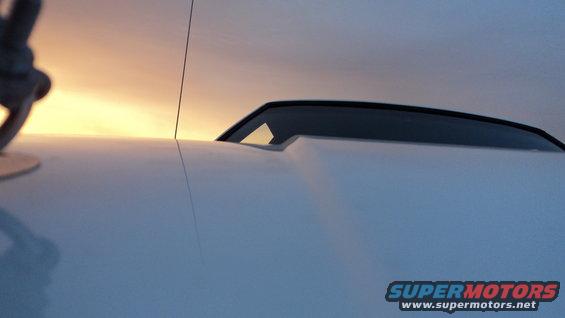 White 1989 Ford Mustang hood with a scoop, seen from a low angle at sunset