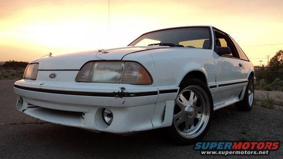 White 1989 Ford Mustang GT parked outdoors at sunset