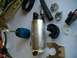 1989 Ford Probe - Various automotive parts laid out, including a fuel pump and a screwdriver.