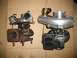 1989 Ford Probe - Comparison of a used turbocharger next to a new one, both resting on a cardboard background.