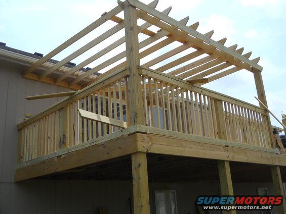Newly constructed wooden deck with a pergola overhead