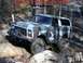 1979 Ford Bronco - This SUV is navigating a challenging off-road course with large rocks and dirt.