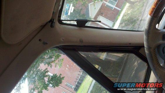 view from inside a vehicle, looking out the windshield and side window. Steering wheel visible on right