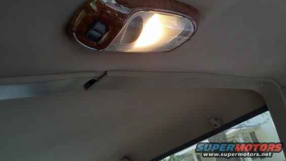 Interior ceiling light with wood trim and a cracked plastic trim piece
