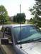 2011 Ford Ranger - A long, thin antenna extends from the hood of a gray truck, with a suburban neighborhood visible behind it.