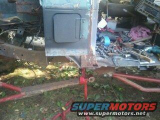 Part of a vehicle body being worked on, with tools and parts scattered around