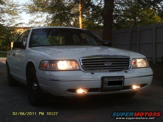White sedan with chrome grille and headlights on. License plate reads MAINE