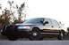 2004 Ford Crown Victoria - A black 2004 Ford Crown Victoria police car is parked outdoors with trees in the background.