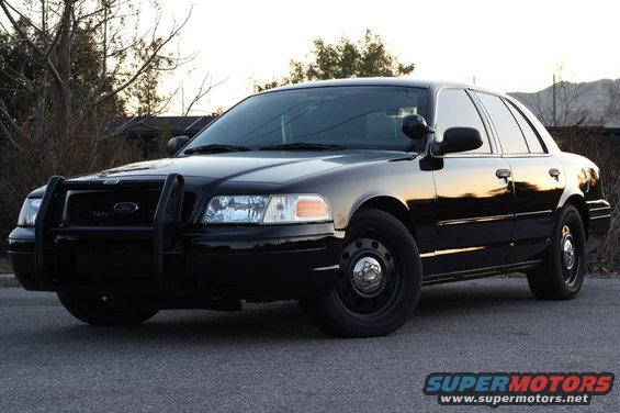Black 2004 Ford Crown Victoria with a push bar, parked on asphalt
