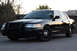 2004 Ford Crown Victoria - This black 2004 Ford Crown Victoria is viewed from a three-quarter front angle, showing its distinctive push bar.