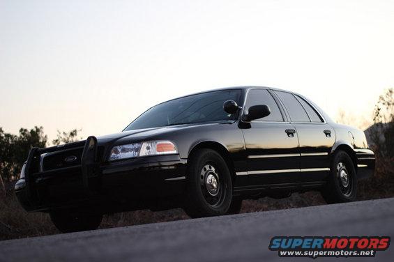 2004 Ford Crown Victoria police car with push bumper parked on a road