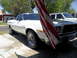 1973 Ford Ranchero - A white 1973 Ford Ranchero is parked in a driveway next to another vehicle, partially hidden by an American flag.