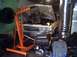 1991 Ford Crown Victoria - Engine hoist positioned to remove the engine from a 1991 Ford Crown Victoria in a garage.