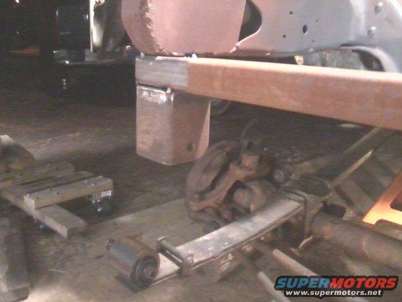 Close-up of vehicle frame modification with suspension components visible