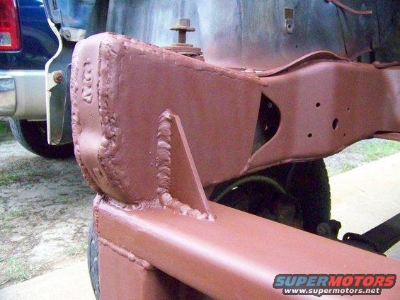 Welded frame section of a vehicle, with a blue truck bumper visible in the background
