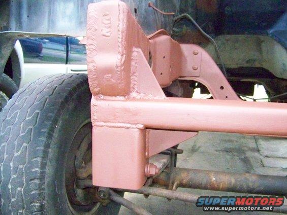 Close-up of a custom frame modification with suspension parts and a tire