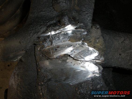 Damaged frame section with visible metal gouges and repair marks