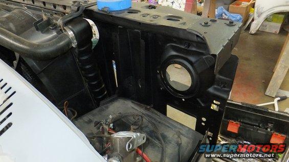 Engine bay area with radiator hose and headlight housing visible. Some parts are disassembled