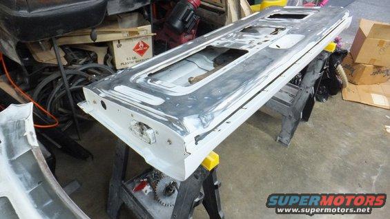 Tailgate on sawhorses, looks like it's being prepped for paint. Some boxes and other car parts in background