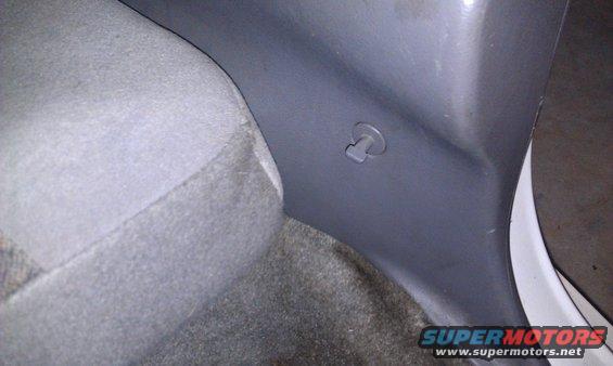 Interior trim panel with a plastic clip visible near a car seat