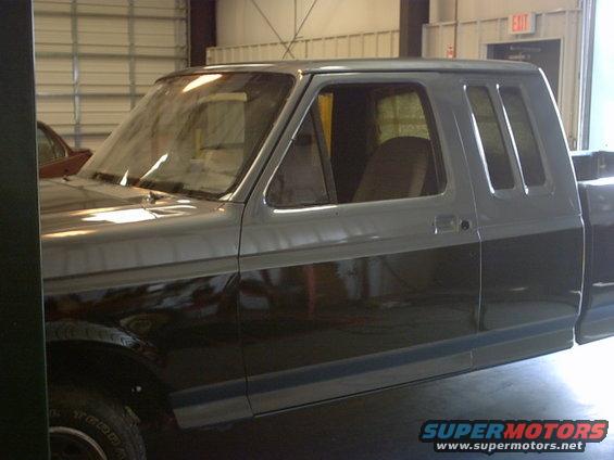 Side view of a two-tone gray 1987-1991 Ford F-150 pickup truck, showing the cab and part of the bed