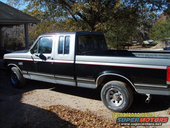 1989 Ford F-150 XLT Lariat SuperCab pickup truck, black and silver two-tone paint with red stripe, parked outdoors