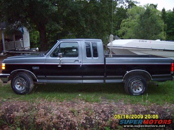 Side view of a 1989 Ford F-150 pickup truck with a boat in the bed