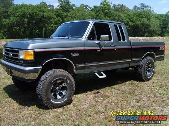 1989 Ford F-150 pickup truck, two-tone black and gray paint, lifted suspension, off-road tires