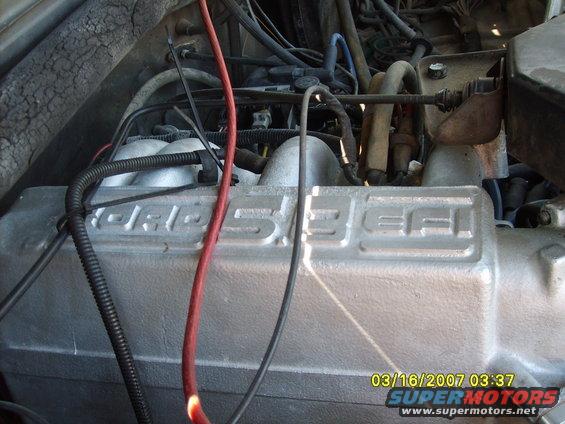 Engine intake manifold with "FORD 5.0 EFI" text. Wires and hoses are visible