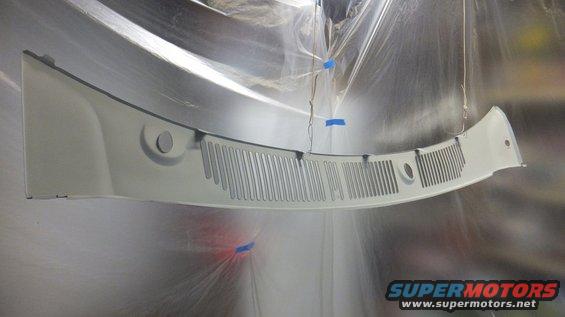 White windshield cowl grille hanging, being painted, with blue tape